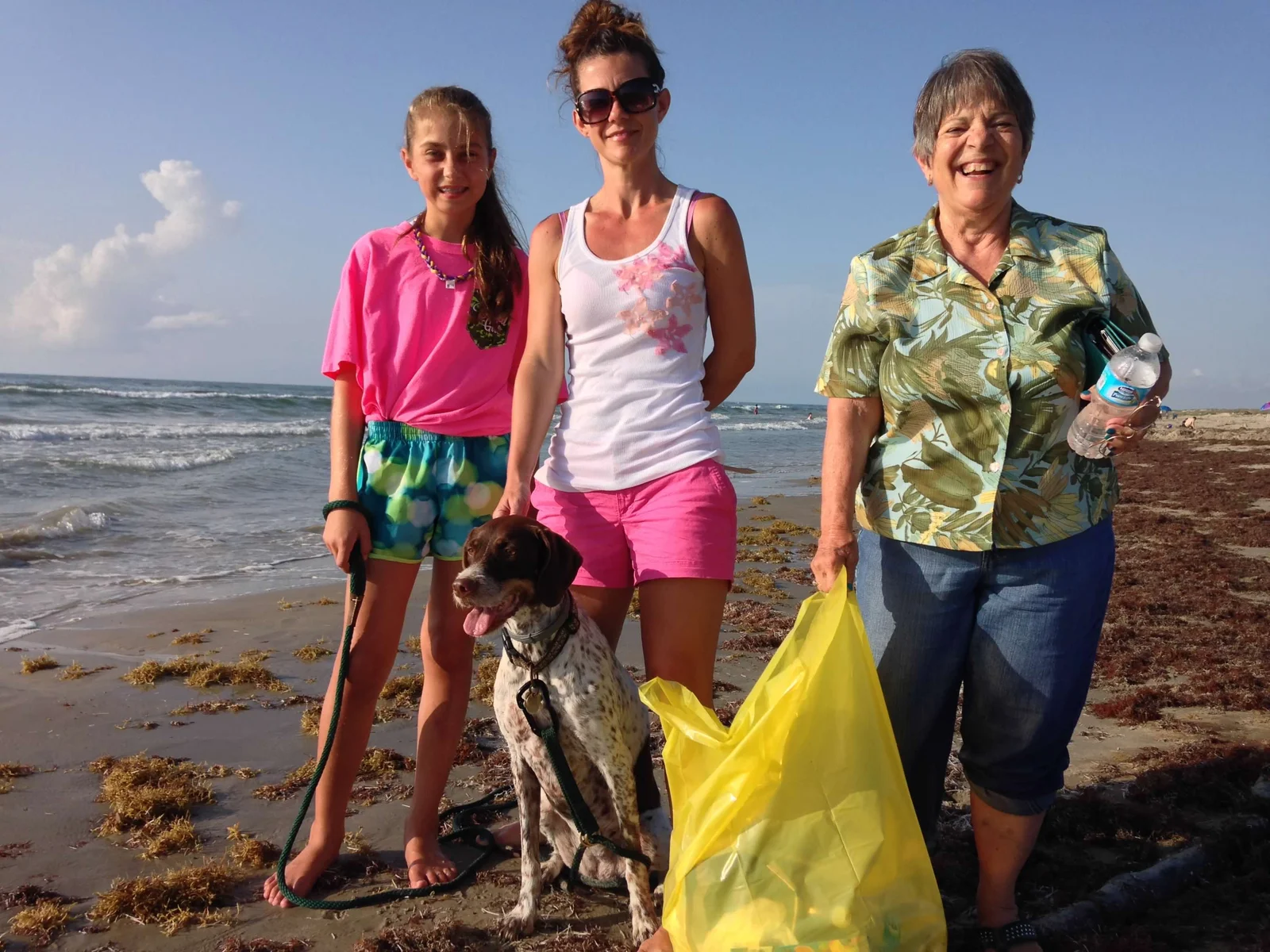 Family on the beach at Padre Island National Seashore after a sea turtle hatchling release, with their dog