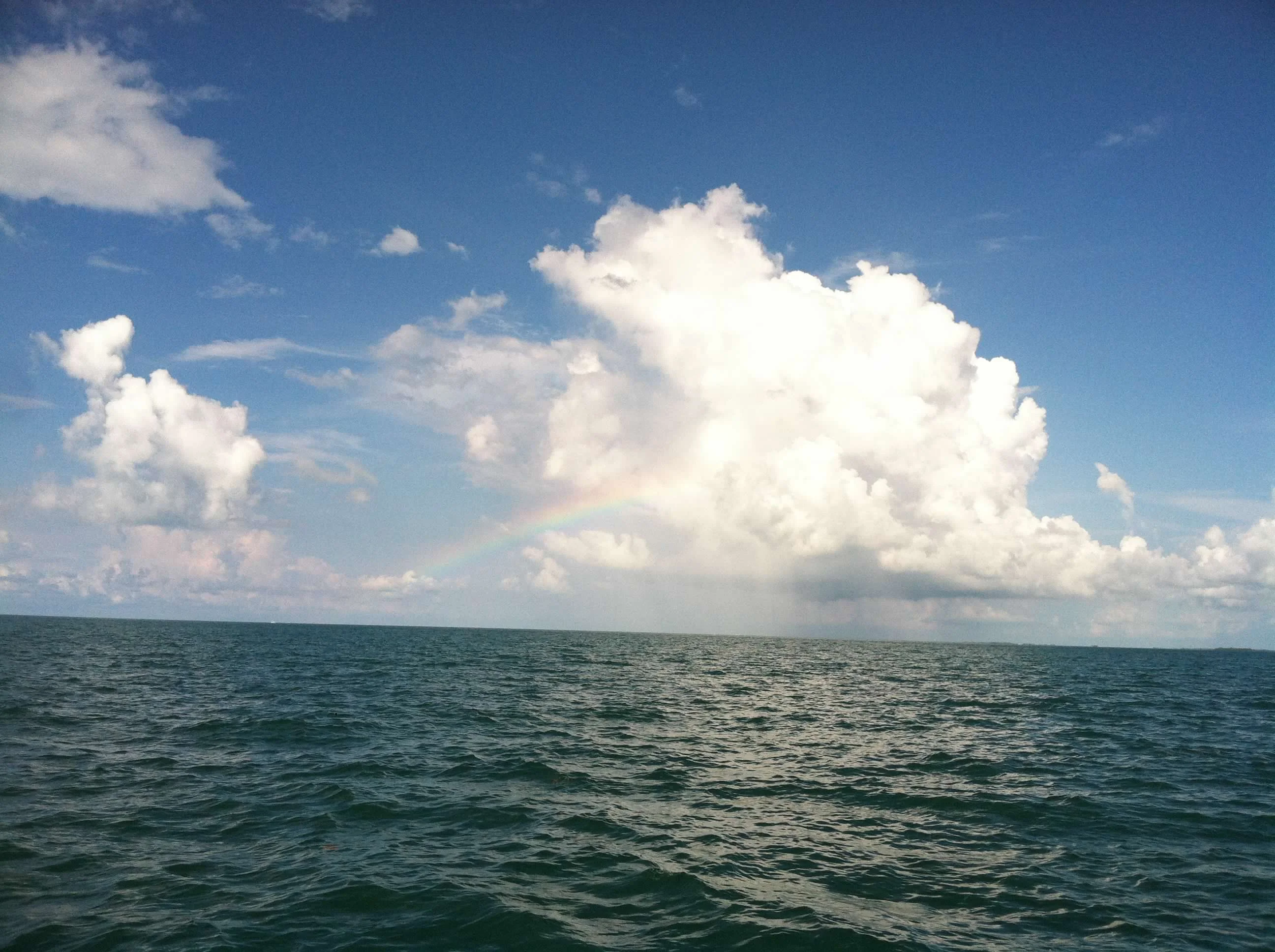 Open ocean off Key West with a rainbow on the horizon, no land visible