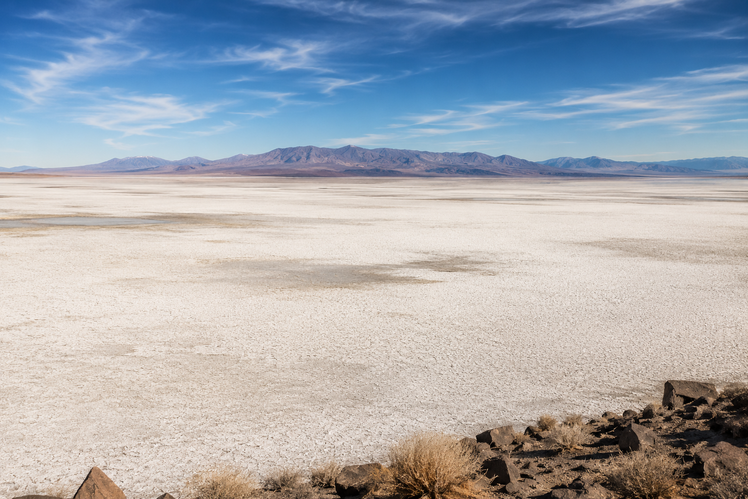 Wide Nevada basin landscape, flat white alkali flats, distant mountains, vast open sky