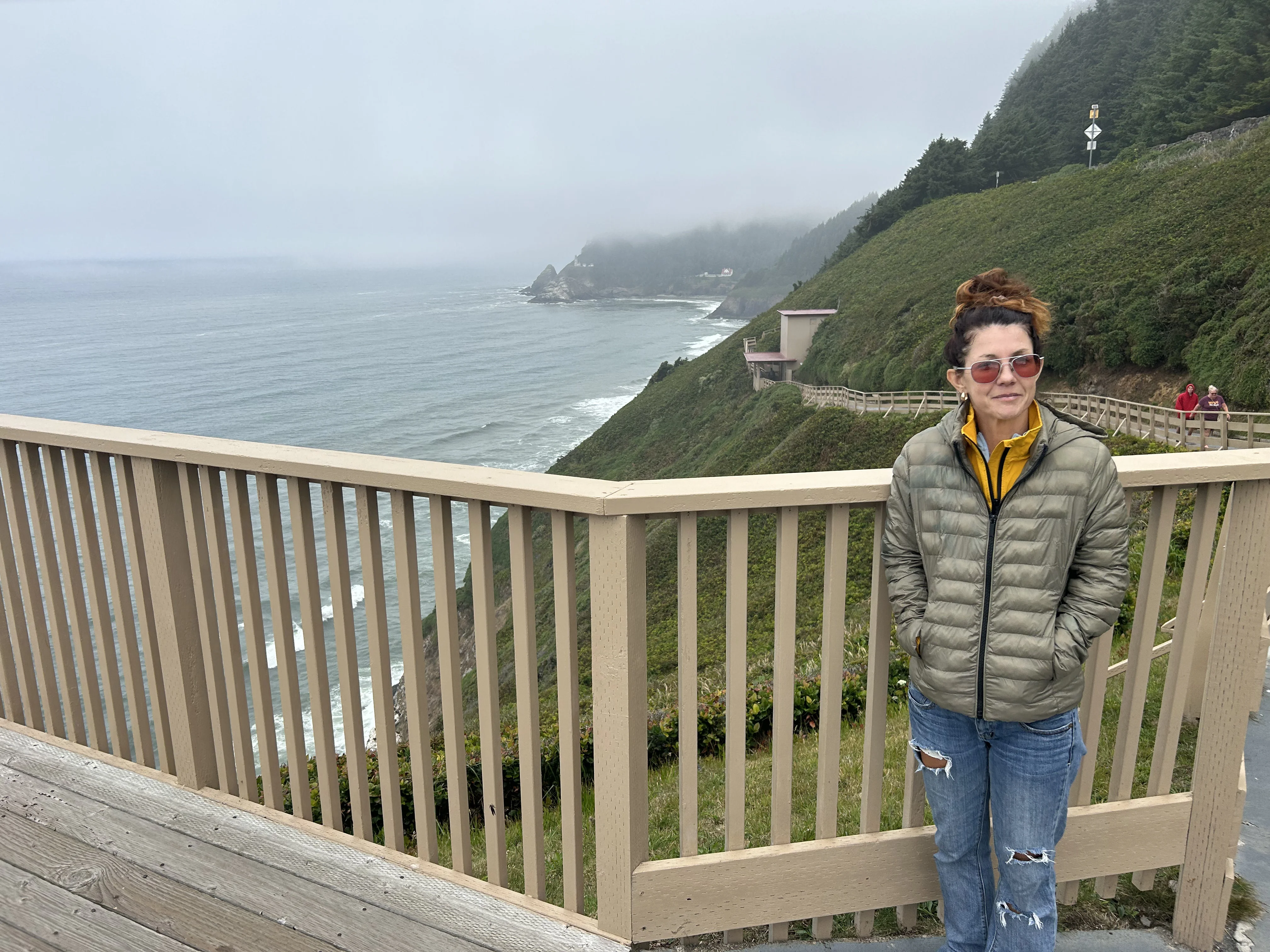 The approach from the US-101 parking area — the entrance building sits right on the headland above the cave